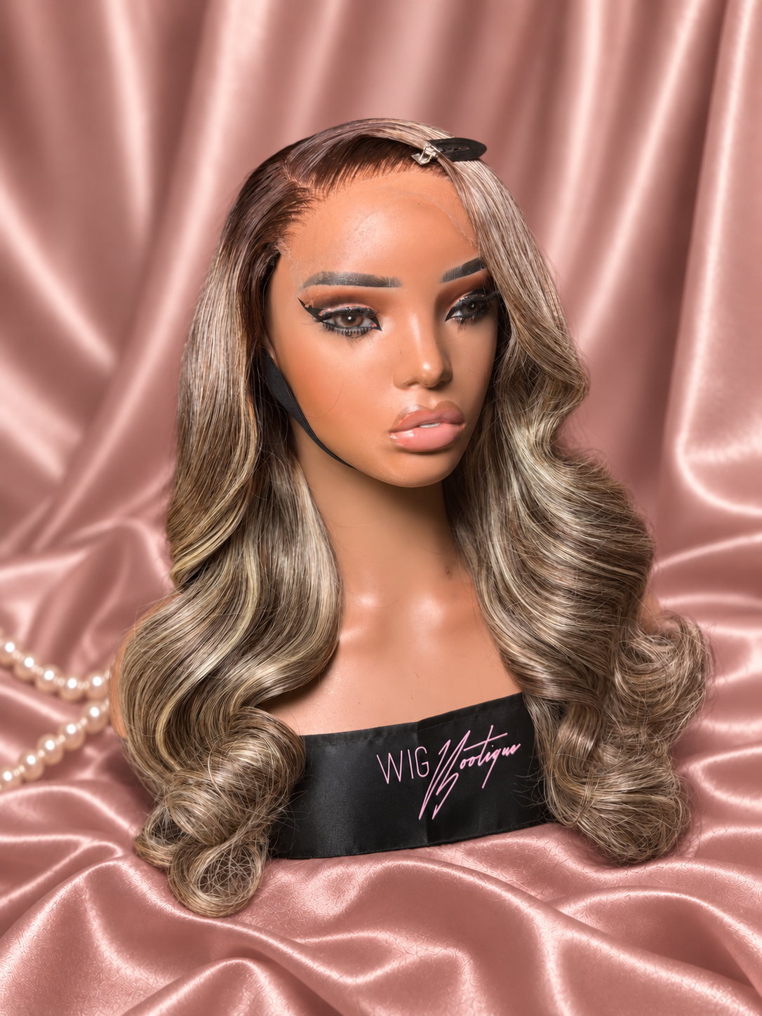 Amoura 18-inch highlighted wig, right-facing view on rose-champagne satin with ivory pearls