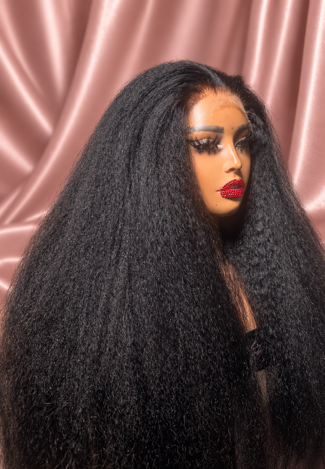Kinky Straight wig texture close-up against rose satin