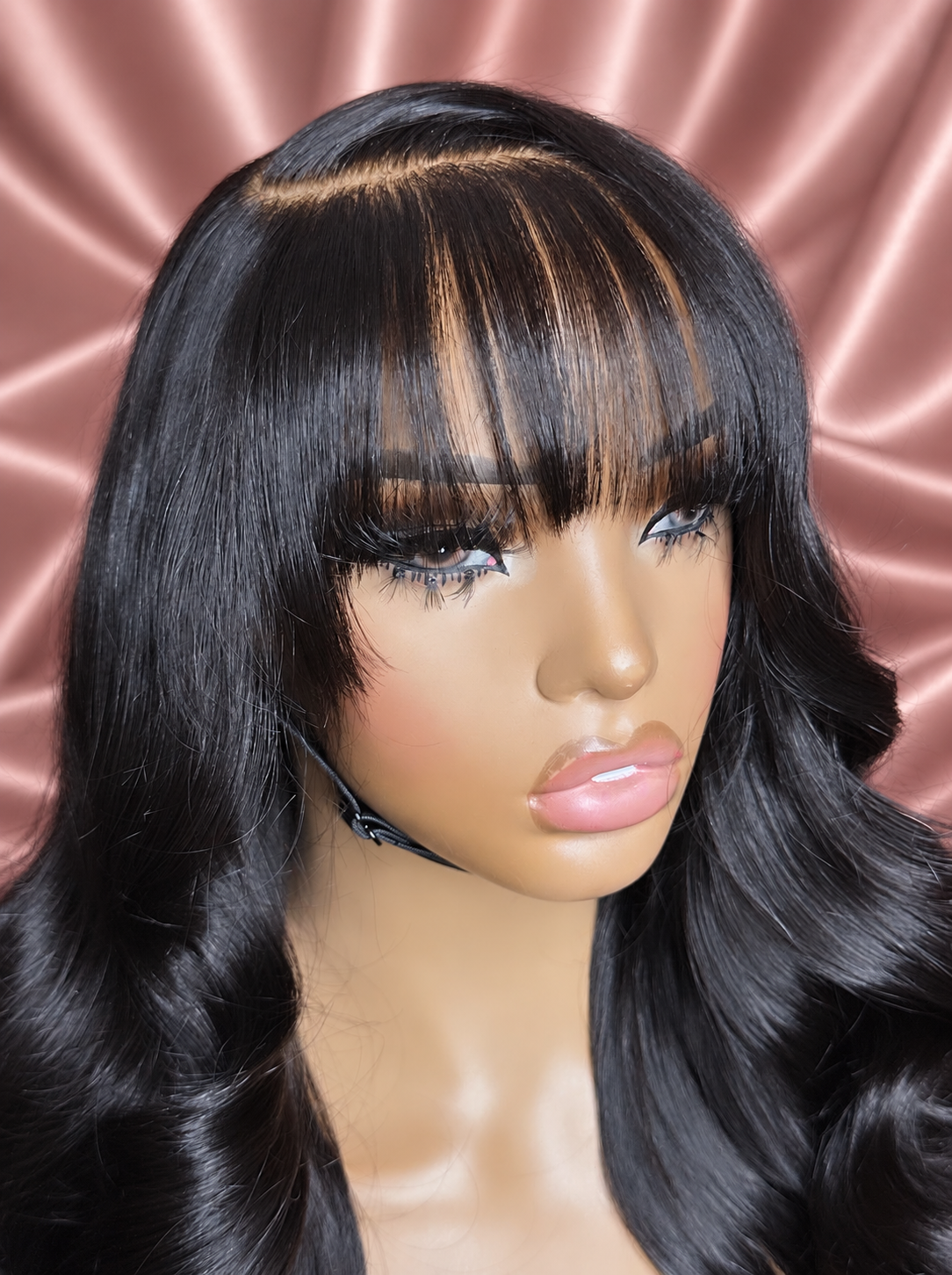 Mecca wig with bangs, close-up 3, against rose-champagne satin